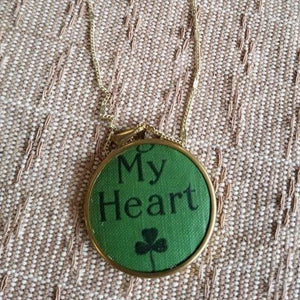 Repurposed Book Cover Necklace made in Overland Park Kansas. Green background, says "My heart" with a shamrock
